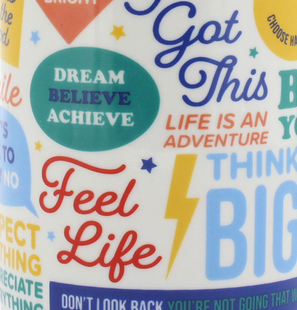 Closeup of coffee mug surface printed with positive sayings and colorful graphics