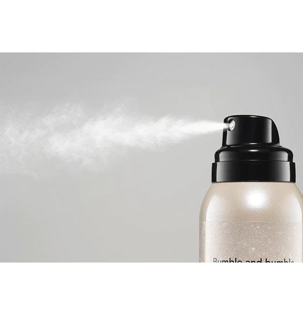 A very fine white mist is dispensed from a can of Bumble and bumble Prêt-à-Powder Très Invisible Dry Shampoo