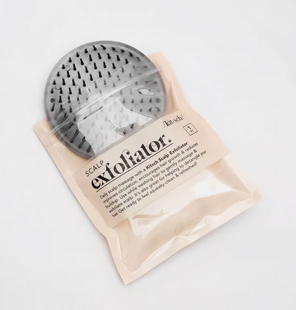 Round gray Kitsch Scalp Exfoliator brush shown halfway removed from packaging