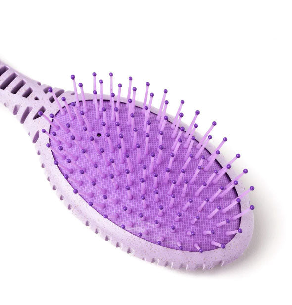Closeup of a purple cushioned paddle hairbrush head