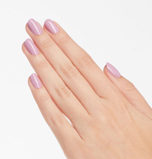 Model's hand wears a soft pastel shade of purple nail polish
