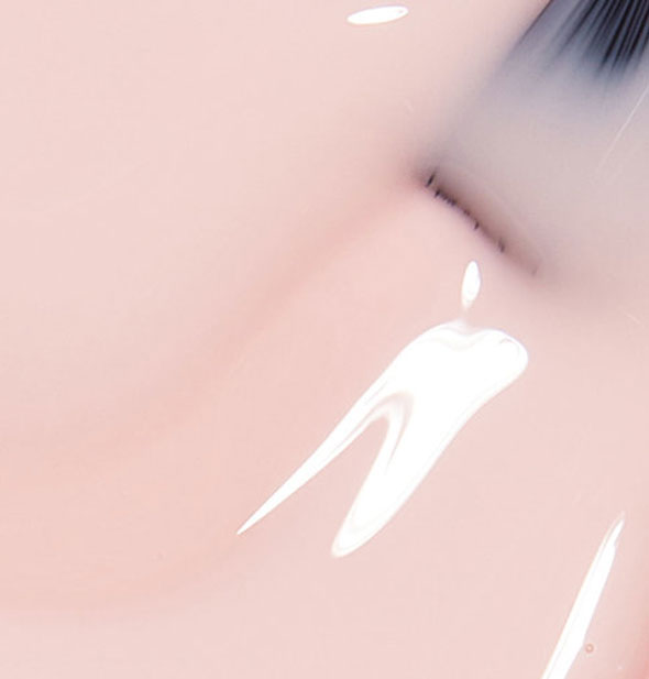 Translucent pale pink nail polish with brush tip dipped into it