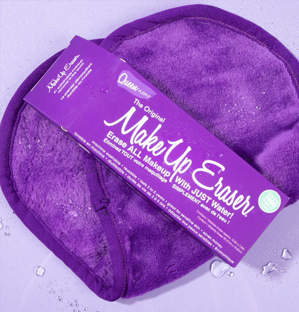 Queen Purple Original MakeUp Eraser with box resting on top of it, both sprinkled with water droplets