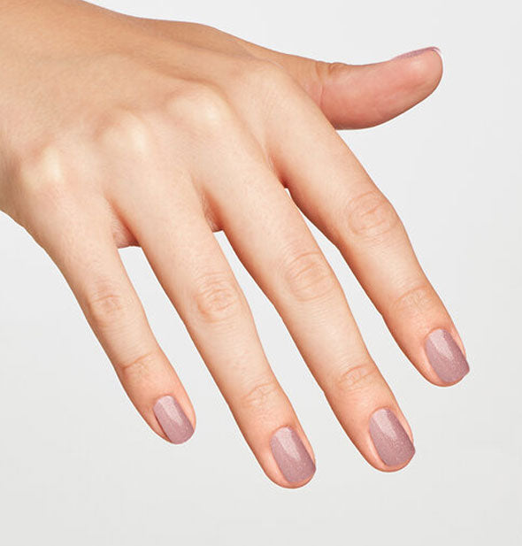 Model's hand wearing a pale purple-pink neutral shade of nail polish