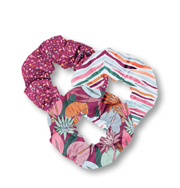 Set of three fabric hair scrunchies in colorful stripe, floral, and speckled patterns