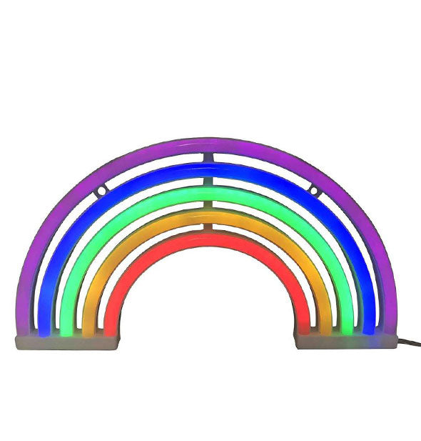 Neon light forms the shape of a rainbow with purple, blue, green, yellow, and red color stripes.