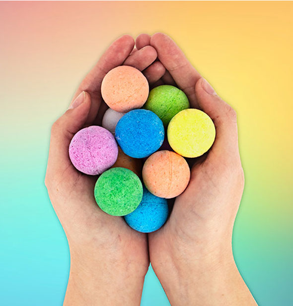 Model's hands hold a grouping of colorful round bath bombs