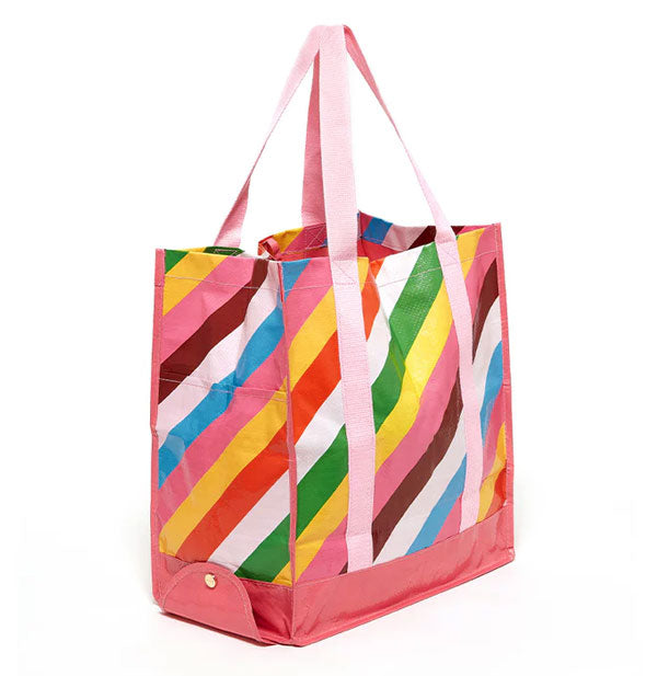 Colorfully-striped tote bag features a dark pink base with side snapped flap and light pink handles extending down the side