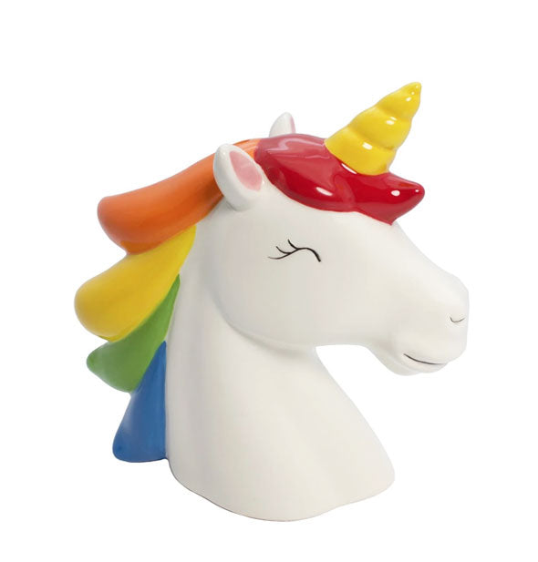 The white ceramic head of a unicorn with yellow horn and colorful mane.