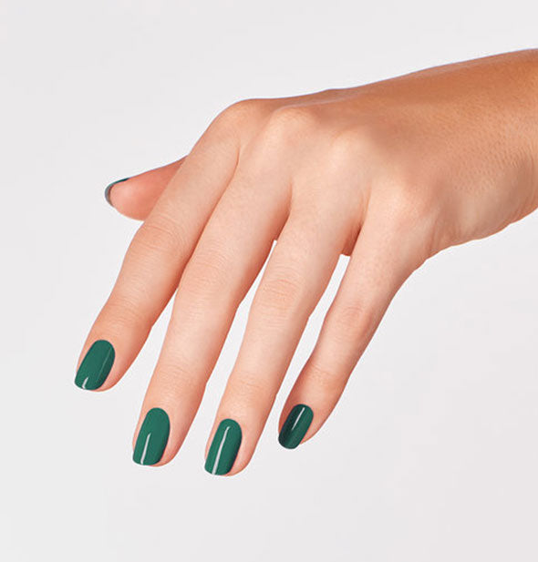 Model's hand wears an emerald green shade of nail polish