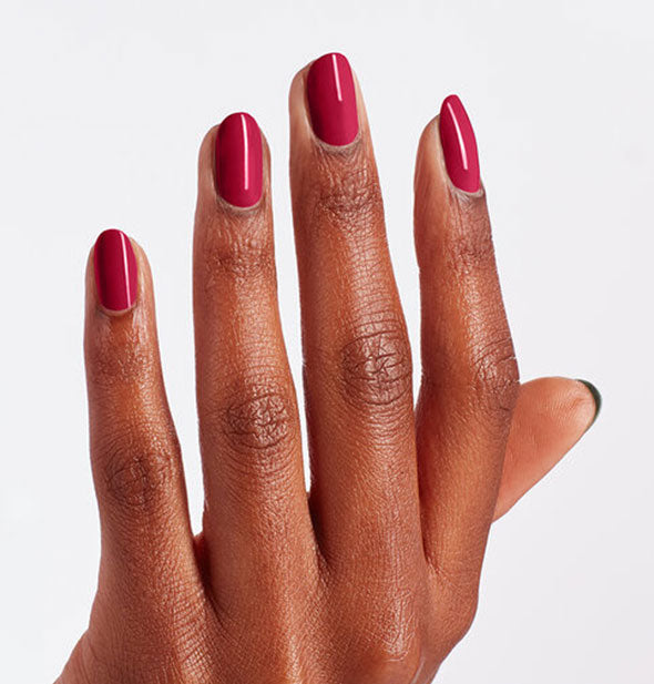 Model's hand wears red nail polish