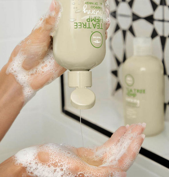 Model pours Paul Mitchell Tea Tree Hemp Restoring Shampoo & Body Wash intro lathered hand