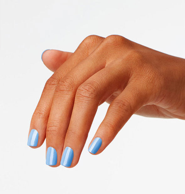 Model's hand wears a sky blue shade of nail polish