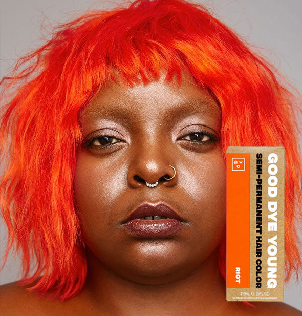 Model with bright orange hair color by Good Dye Young in the shade Riot