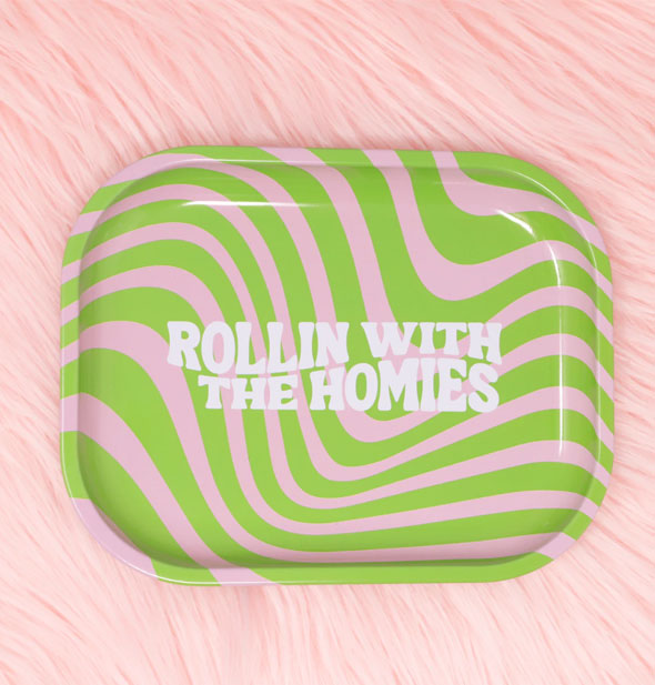 Rectangular tray with rounded corners says, "Rollin with the homies" in curved white lettering on a pink and green striped background sits on a pink fur backdrop