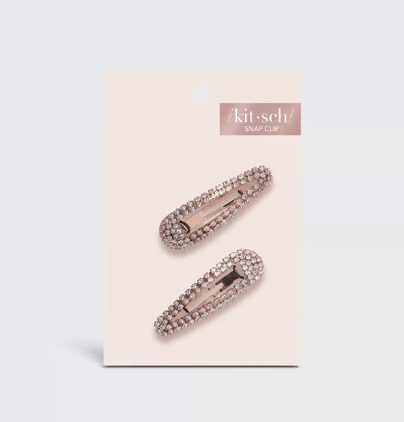 Two rhinestone-encrusted rose gold snap clips on a light pink Kitsch product card