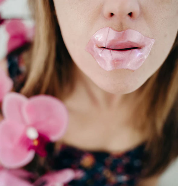 Model demonstrates use of a pink gel lip mask over mouth area