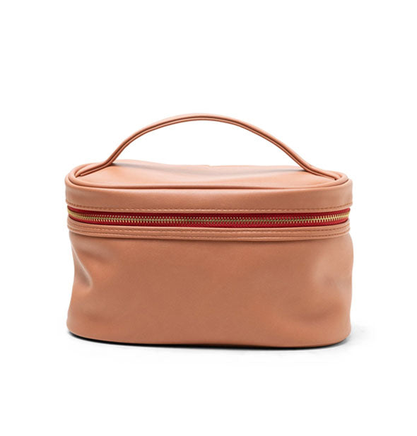 Salmon-colored vegan leather travel case with matching top handle, red zipper tape, and gold zipper hardware