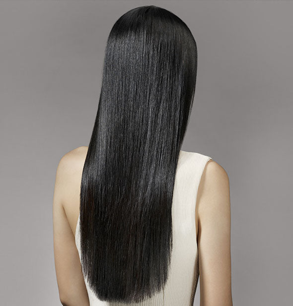 Long, straight, shiny hair is styled with Oribe Royal Blowout Heat Styling Spray