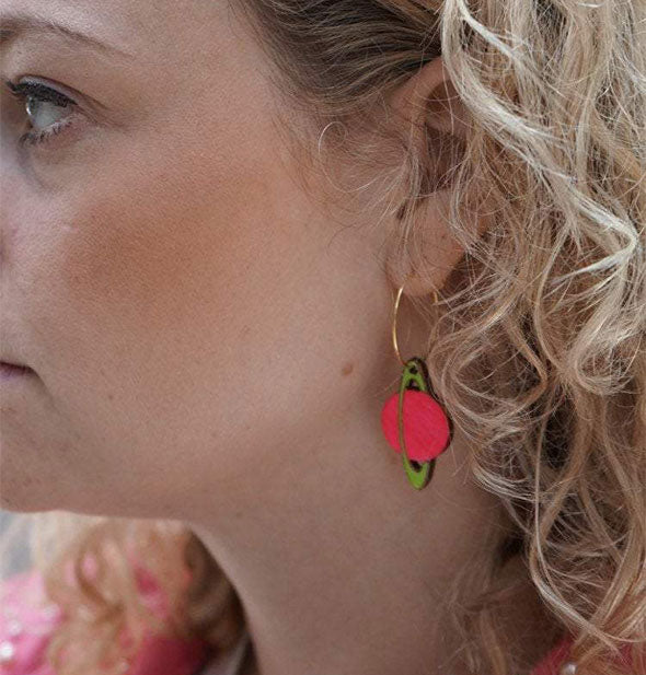 Model wears a pink and green Saturn earring