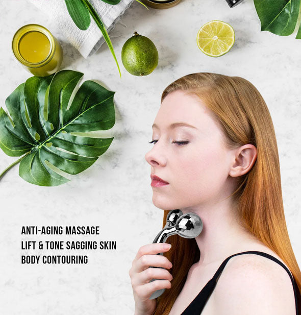 Model uses Sculpting Massager on neck underneath accents of limes and tropical leaves with caption, "Anti-aging massage; Lift & tone sagging skin; Body contouring" 