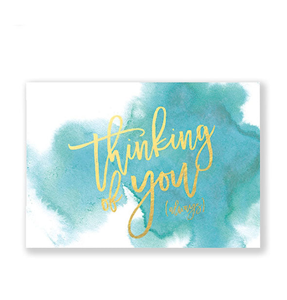 WHite rectangular greeting card with blue-green watercolor blotting says, "Thinking of you" in metallic gold script