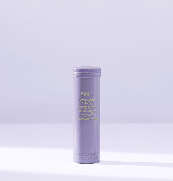 Slender cylindrical purple bottle of Oribe Serene Scalp Oil Control Dry Shampoo Powder on a purple background