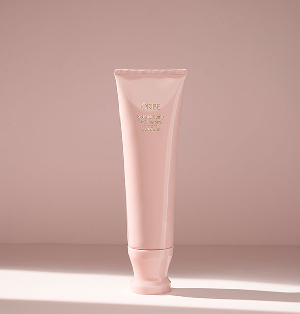 Light pink tube of Oribe Serene Scalp Exfoliating Scrub on blush background