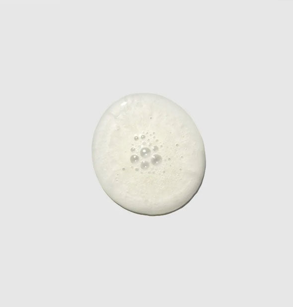 Slightly bubbly sample droplet of Paul Mitchell Tea Tree Scalp Care Anti-Thinning Shampoo