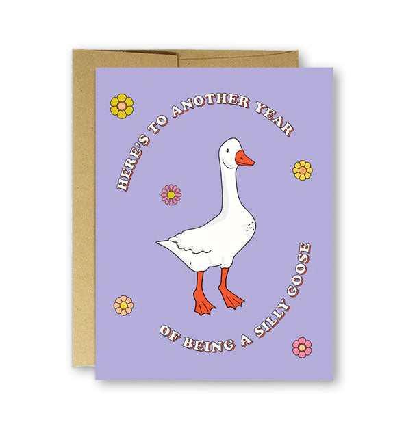 Purple greeting card with illustration of a white goose amid flower accents says, "Here's to another year of being a silly goose" in white lettering