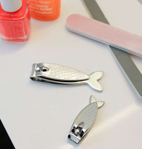 One large and one small fish-shaped silver toenail clipper