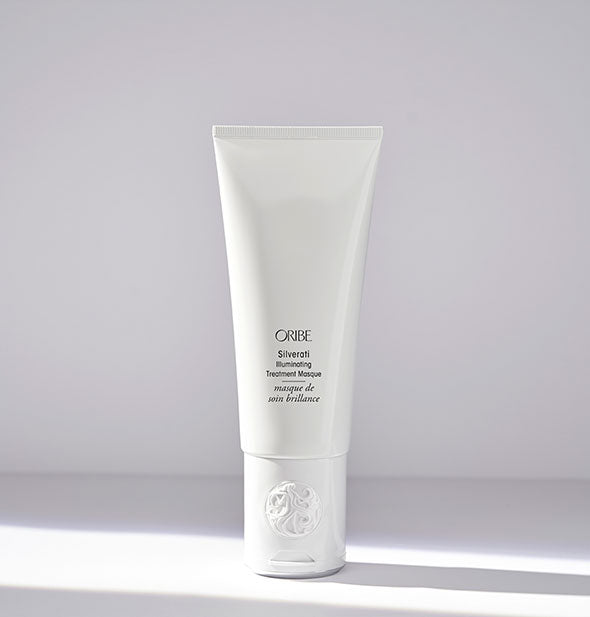White bottle of Oribe Silverati Illuminating Treatment Masque on light gray background