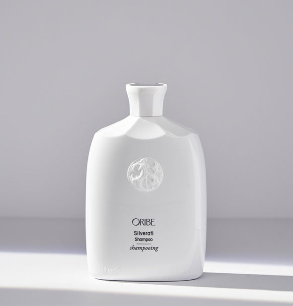 White bottle of Oribe Silverati Shampoo on light gray background
