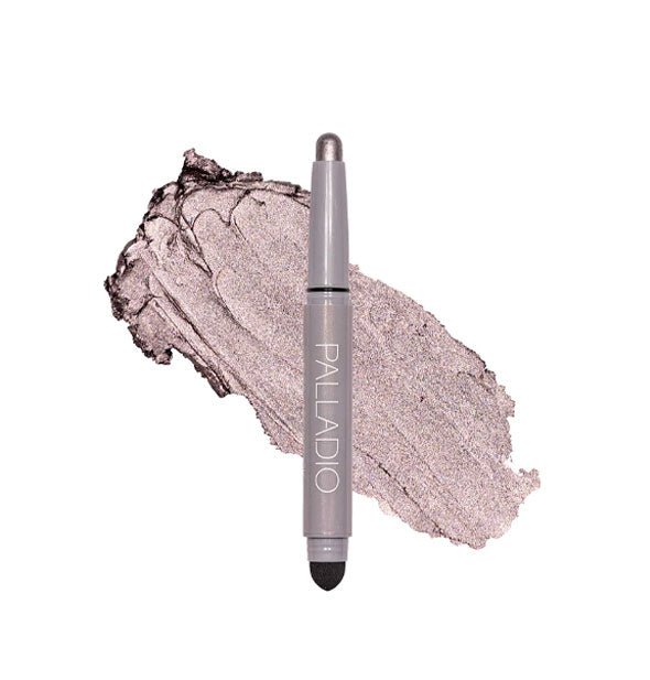 Double-ended Palladio eyeshadow stick with color at one end and black blending sponge at the other rests in front of a color swatch sample in the shade Silver Mauve Shimmer