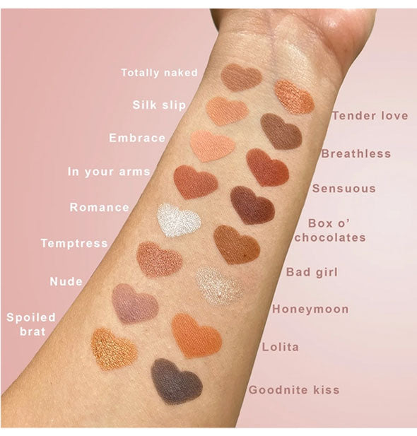 Inside of model's forearm with heart-shaped applications of the 16 shades in the Sinful Eyes Teddy Bare Eyeshadow Palette with names labeled on either side