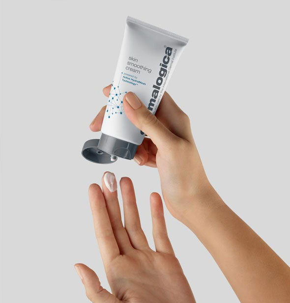 Model dispenses some Dermalogica Skin Smoothing Cream from bottle onto fingertips