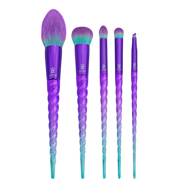 Five makeup brushes with teal-to-purple ombré coloration on the bristles and handles which resemble unicorn horns