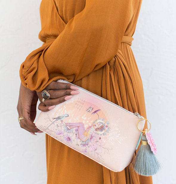A model holds the small Live Your Best Life Tassel Pouch