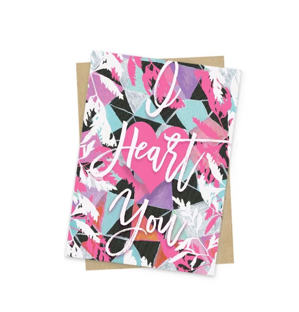 Colorful greeting card with geometric shapes and white leaf illustrations says, "I Heart You" in large white script