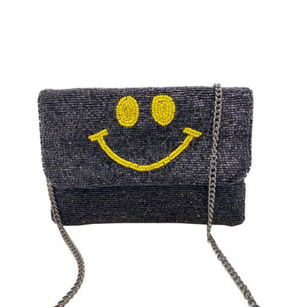 Rectangular black beaded purse with central yellow smiley face design and silver chain strap