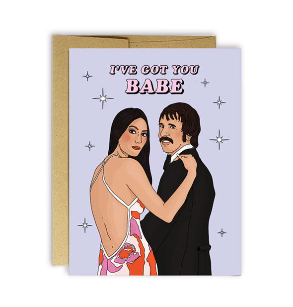 Light purple greeting card with kraft envelope features illustration of Sonny and Cher accented by stars and says, "I've got you babe" in pink lettering at the top