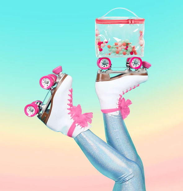 Model wearing pink and white rollerskates balances a pom pom bag on one set of wheels