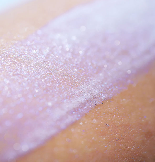 Sample application of purple Unicorn Snot BioGlitter Sunscreen on skin shows its slight sparkle