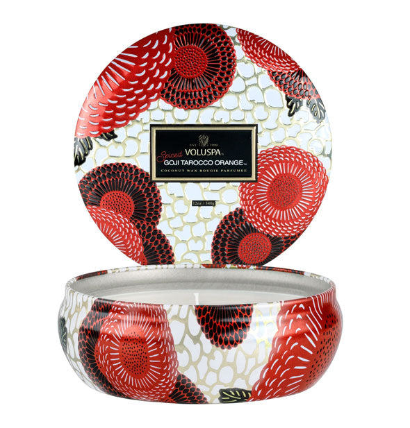 Decorative tin candle with black, red, and white floral pattern