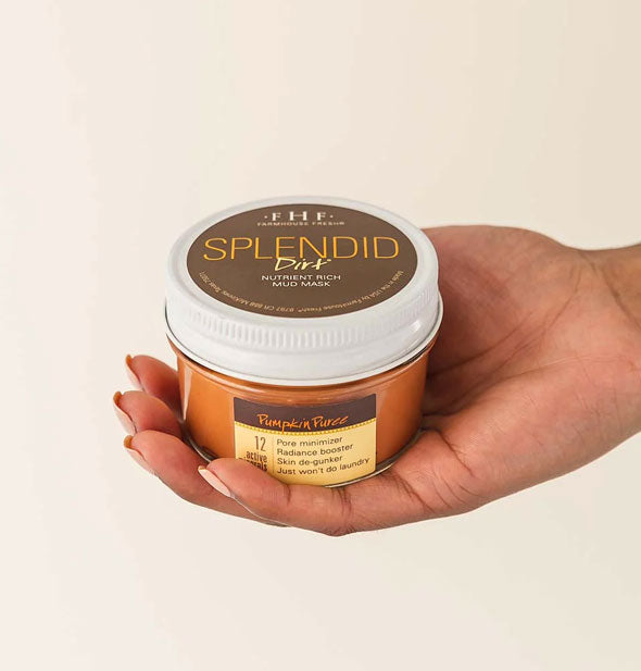 Model's hand holds a jar of Splendid Dirt Pumpkin Puree mask