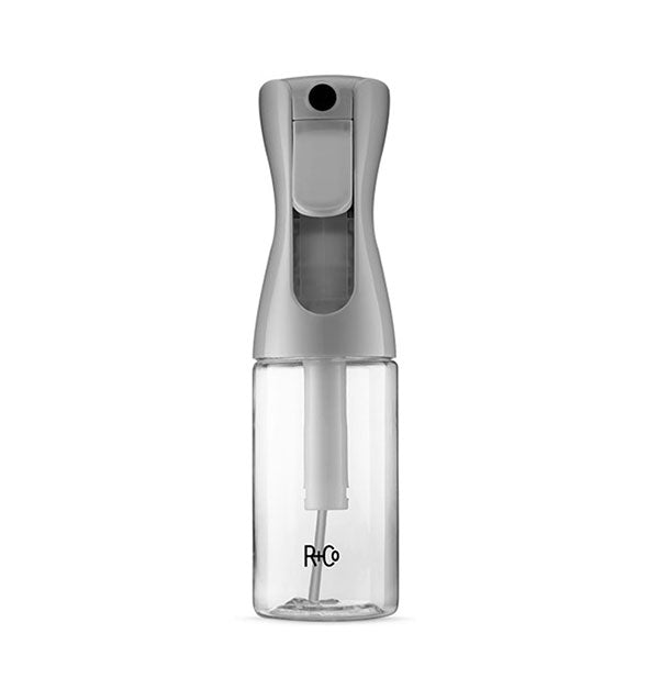 Spray bottle with gray top and clear bottom printed with R+Co logo in black