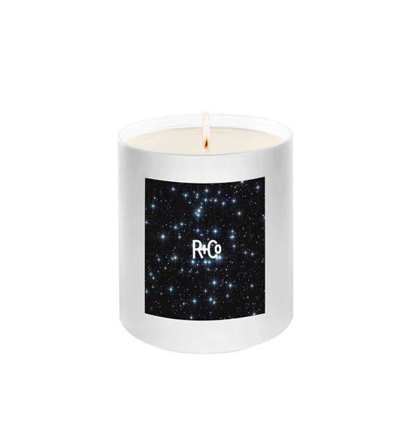 Lit R+Co candle in white glass with starry night sky label