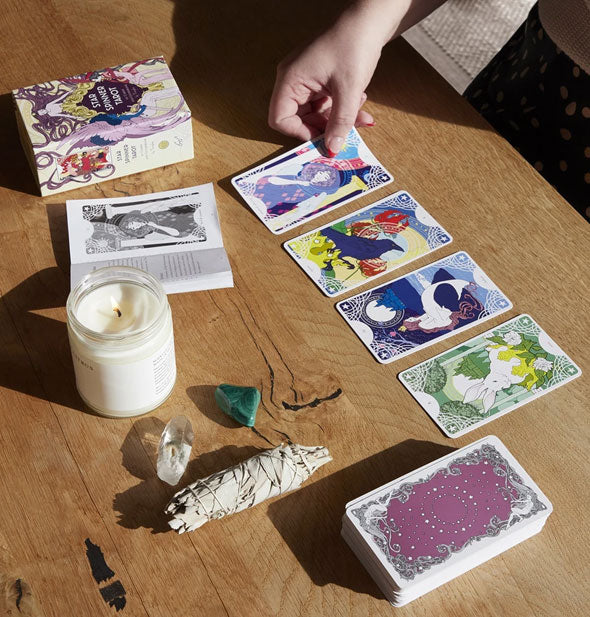 Star Spinner Tarot cards laid out on wooden surface with sage, crystals, and lit candle