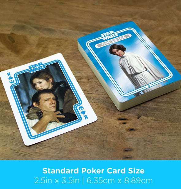 Stack of Princess Leia playing cards with king of clubs shown on wooden surface are captioned, "Standard Poker Card Size" with dimensions in inches and centimeters