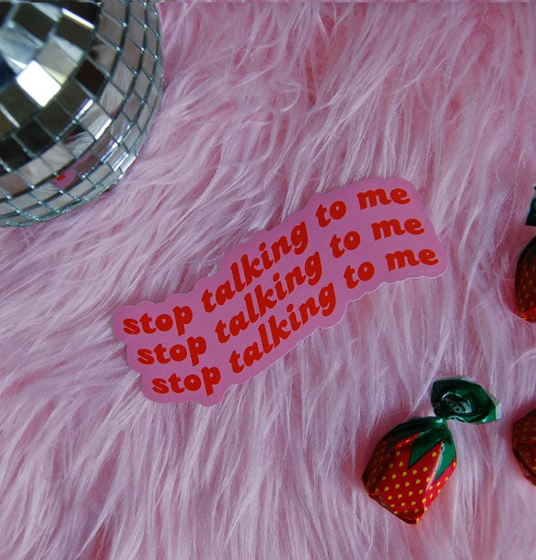 Stop Talking to Me sticker on a pink fur background staged with a disco ball and strawberry candy